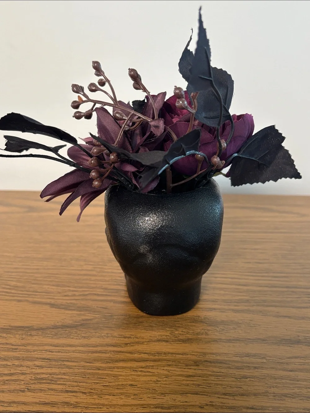 Black Skull Vase with Dark Purple Floral Arrangement